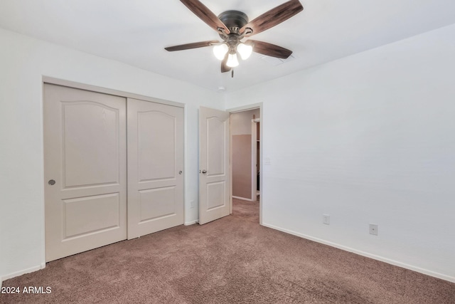 unfurnished bedroom featuring ceiling fan, a closet, and carpet flooring