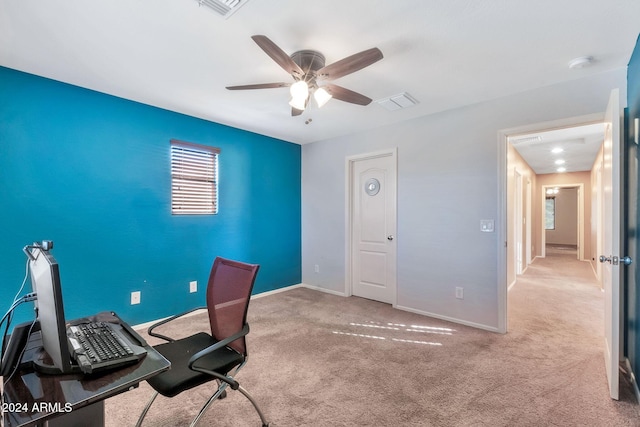 unfurnished office with ceiling fan and light colored carpet