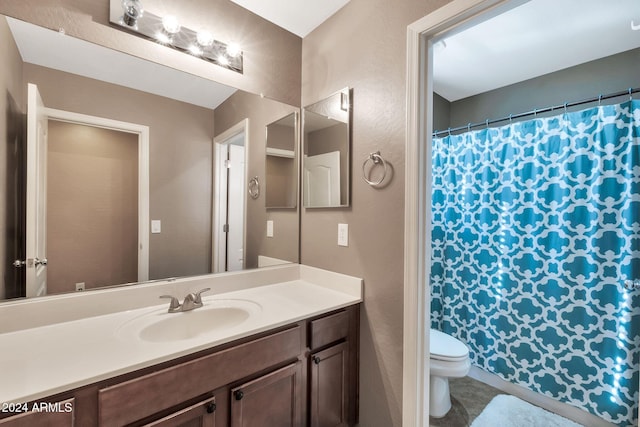 bathroom featuring toilet, vanity, and tile patterned flooring