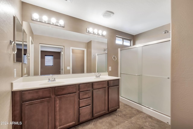 bathroom with tile patterned flooring, walk in shower, and vanity