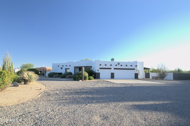 pueblo revival-style home featuring a garage