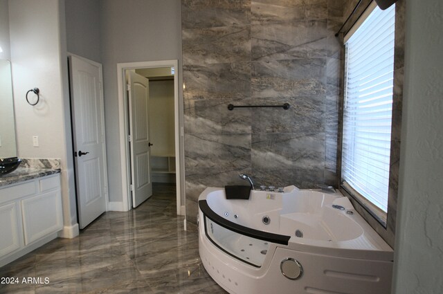 bathroom with vanity, tile walls, and a bath