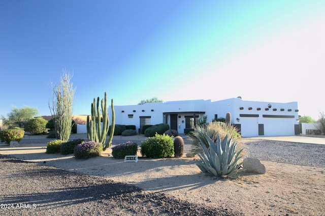 pueblo revival-style home featuring a garage