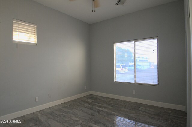 unfurnished room featuring ceiling fan and a wealth of natural light