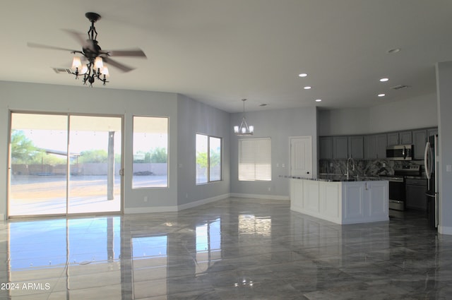 kitchen with appliances with stainless steel finishes, decorative backsplash, hanging light fixtures, and plenty of natural light