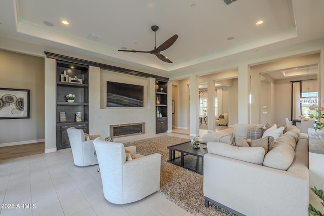8768 E Granite Pass Rd, Scottsdale, AZ 85266 - living room with built in features, a ceiling fan, a tray ceiling, and baseboards
