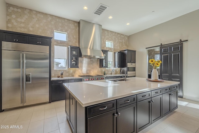 8768 E Granite Pass Rd, Scottsdale, AZ 85266 - kitchen with visible vents, island exhaust hood, wallpapered walls, a sink, and stainless steel built in fridge