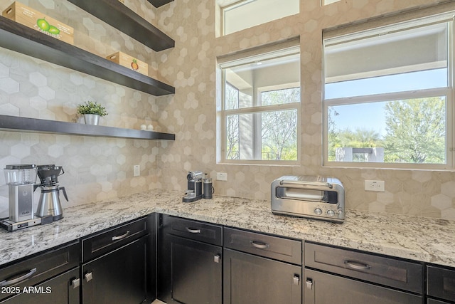 8768 E Granite Pass Rd, Scottsdale, AZ 85266 - kitchen with a wealth of natural light, light stone counters, decorative backsplash, and open shelves