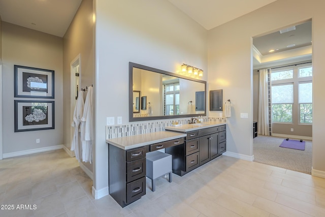 8768 E Granite Pass Rd, Scottsdale, AZ 85266 - bathroom featuring a tray ceiling, vanity, baseboards, visible vents, and decorative backsplash