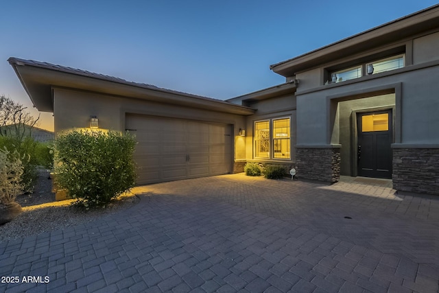 8768 E Granite Pass Rd, Scottsdale, AZ 85266 - exterior space featuring stucco siding, a garage, stone siding, and decorative driveway