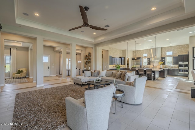 8768 E Granite Pass Rd, Scottsdale, AZ 85266 - living area featuring light tile patterned flooring, visible vents, crown molding, a ceiling fan, and a raised ceiling