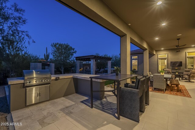 8768 E Granite Pass Rd, Scottsdale, AZ 85266 - patio at night with an outdoor hangout area, grilling area, a ceiling fan, an outdoor kitchen, and a pergola