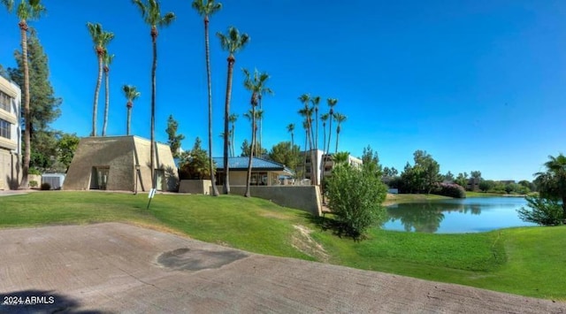 view of community with a water view and a yard