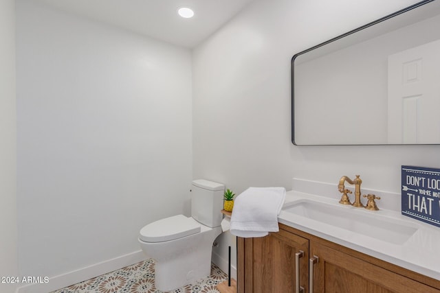 half bath featuring recessed lighting, baseboards, vanity, and toilet