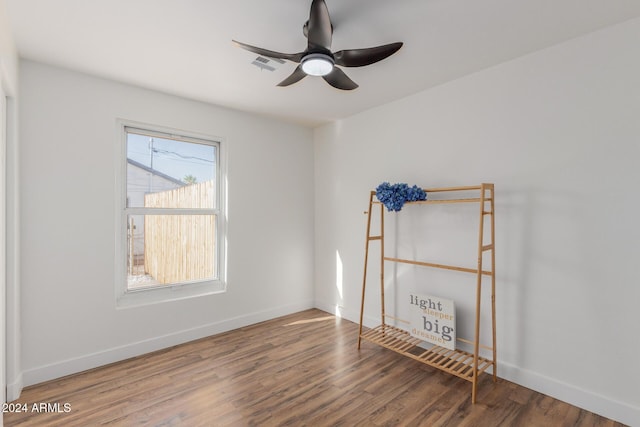 empty room featuring visible vents, ceiling fan, baseboards, and wood finished floors