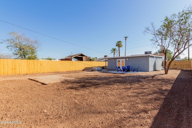 view of yard with a patio, french doors, and a fenced backyard