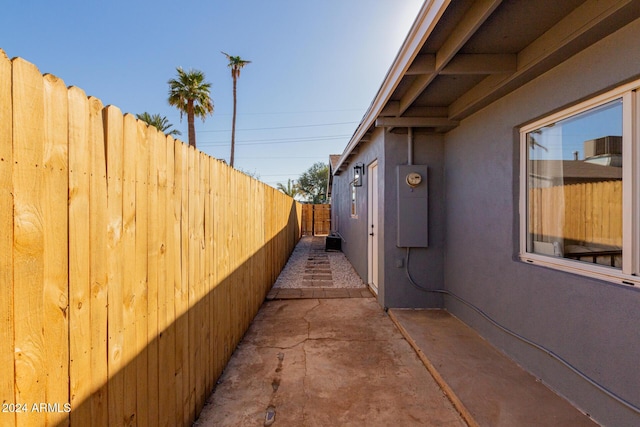 view of side of home featuring fence, a patio, and stucco siding