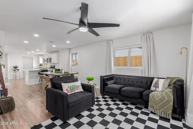 living room featuring light hardwood / wood-style flooring and ceiling fan