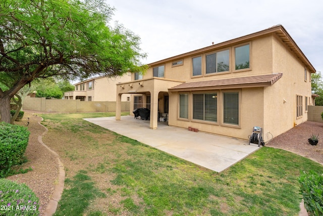 rear view of house with a patio area and a yard