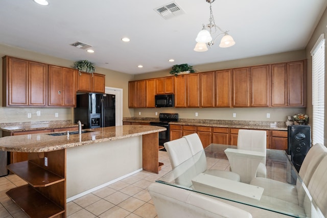 kitchen featuring pendant lighting, a kitchen island with sink, an inviting chandelier, black appliances, and sink