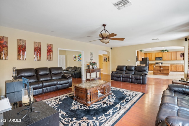 living room with ceiling fan and light wood-type flooring