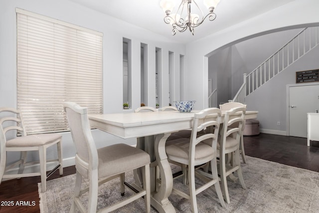 dining space featuring a notable chandelier and dark wood-type flooring