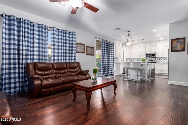 living room featuring dark hardwood / wood-style floors and ceiling fan