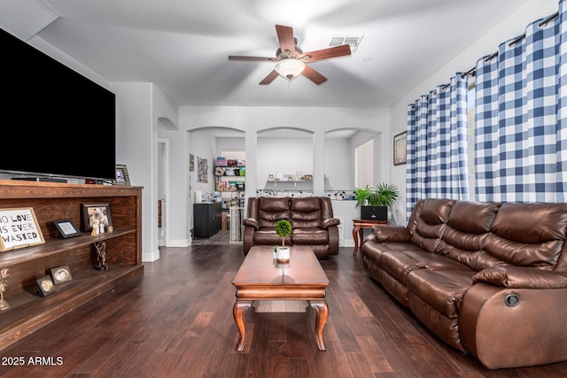 living room featuring dark wood-type flooring and ceiling fan