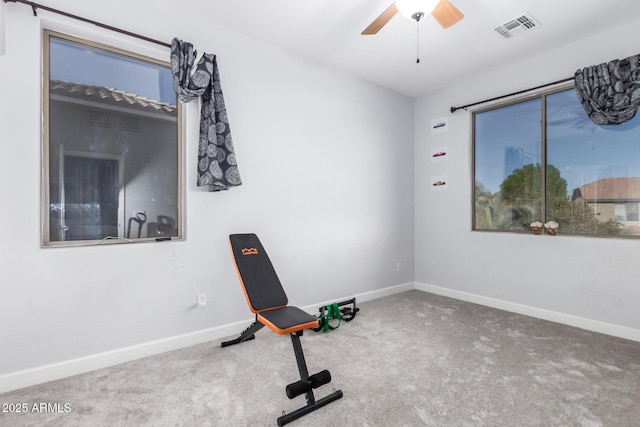 workout room with ceiling fan and carpet