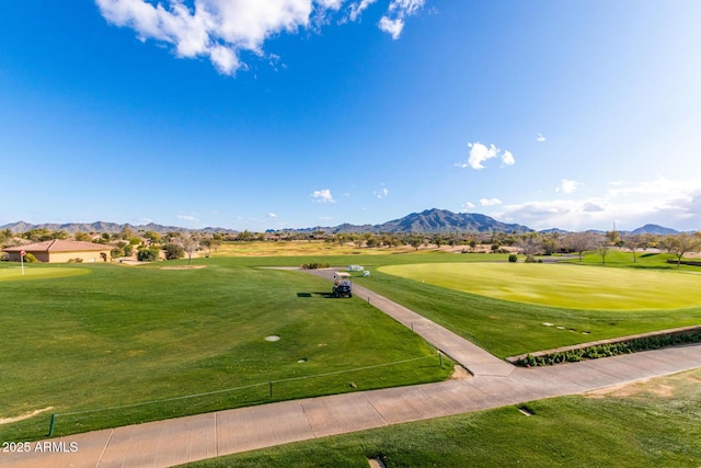 surrounding community with a mountain view and a yard