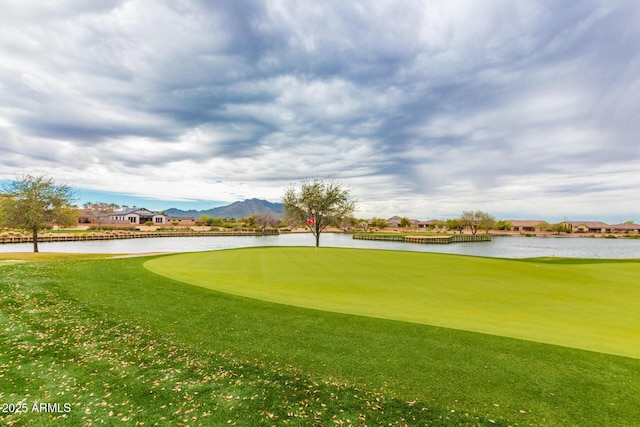 view of property's community featuring a lawn and a water and mountain view