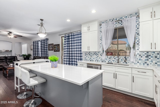 kitchen with sink, white cabinetry, decorative backsplash, and hanging light fixtures