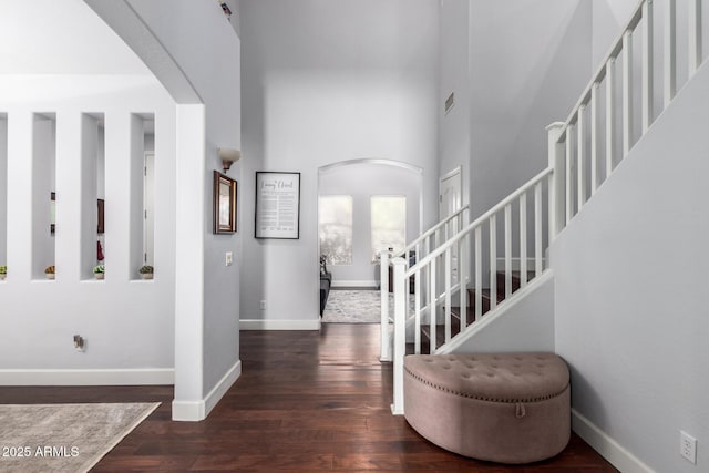 foyer featuring dark hardwood / wood-style flooring and a towering ceiling