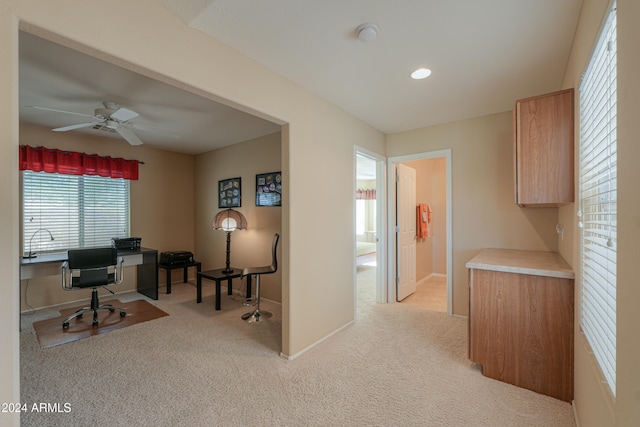 carpeted home office featuring ceiling fan