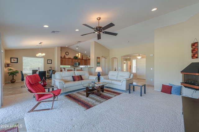 carpeted living room featuring ceiling fan with notable chandelier and lofted ceiling