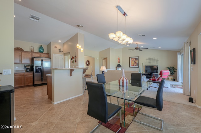 tiled dining space with ceiling fan and vaulted ceiling