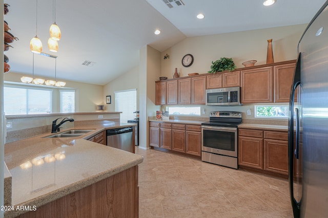 kitchen with a wealth of natural light, decorative light fixtures, stainless steel appliances, and lofted ceiling