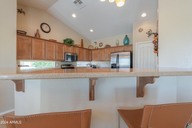 kitchen with a kitchen breakfast bar, kitchen peninsula, and appliances with stainless steel finishes