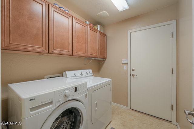 clothes washing area with cabinets and separate washer and dryer