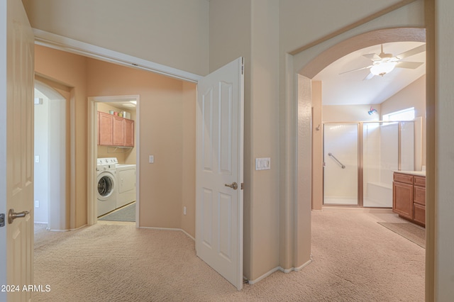 corridor featuring light colored carpet, separate washer and dryer, and vaulted ceiling