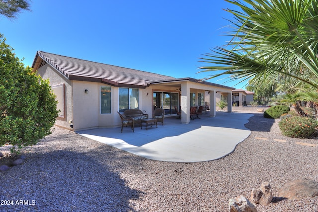 back of house featuring an outdoor living space and a patio area