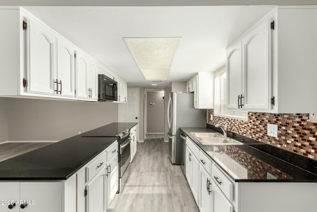 kitchen featuring sink, light hardwood / wood-style flooring, white cabinetry, electric range, and decorative backsplash