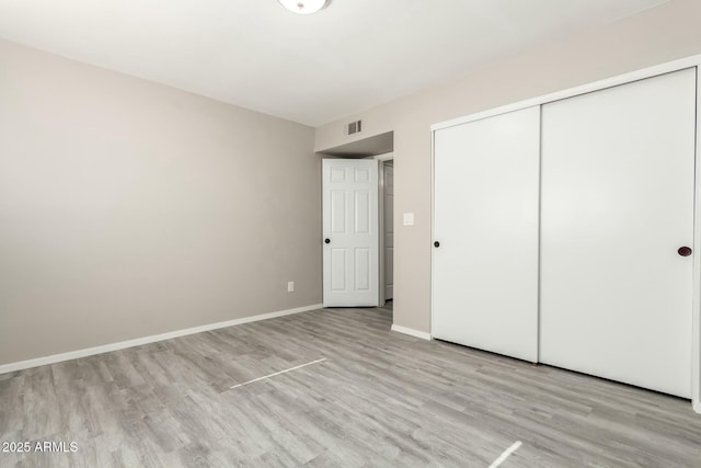 unfurnished bedroom featuring light hardwood / wood-style floors and a closet