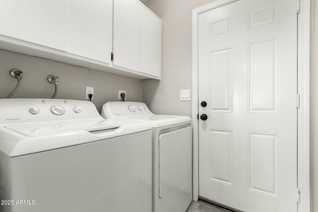 laundry room featuring washer and clothes dryer and cabinets