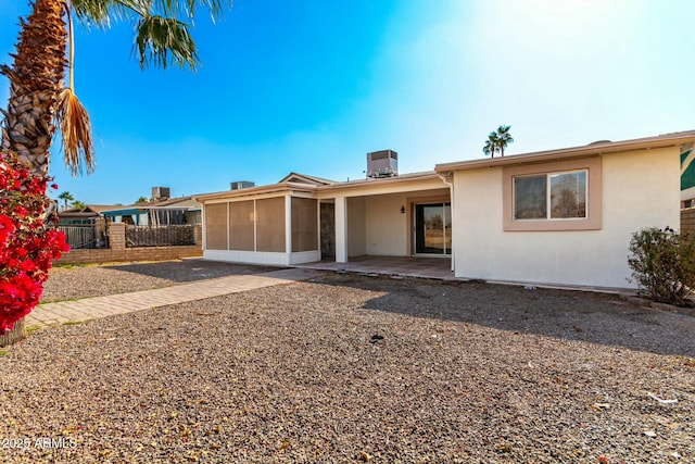 ranch-style house featuring central AC unit, a patio area, and a sunroom