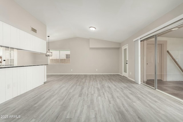 unfurnished living room featuring light hardwood / wood-style floors and vaulted ceiling