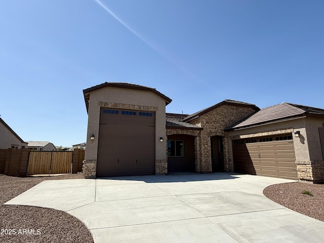 17308 W Royal Palm Rd, Waddell, AZ 85355 - view of front of house with a garage, driveway, stone siding, and stucco siding
