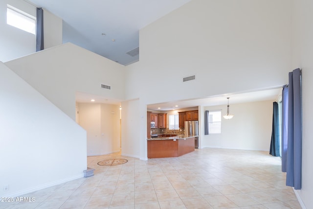 231 N Nash Way, Chandler, AZ 85225 - unfurnished living room featuring a towering ceiling, baseboards, and visible vents