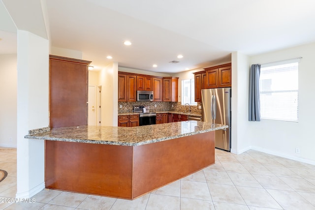 231 N Nash Way, Chandler, AZ 85225 - kitchen with light stone counters, a sink, a peninsula, decorative backsplash, and appliances with stainless steel finishes