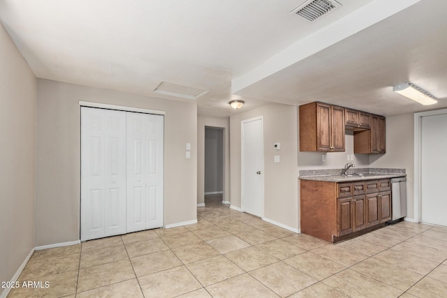 kitchen featuring visible vents, dishwasher, light countertops, a sink, and light tile patterned floors